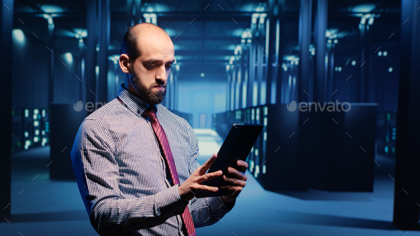 Data center IT engineer standing in server room - Stock Photo - Images