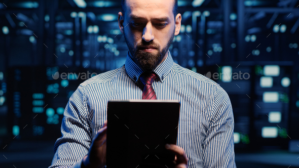 IT web technician working in data center with tablet - Stock Photo - Images