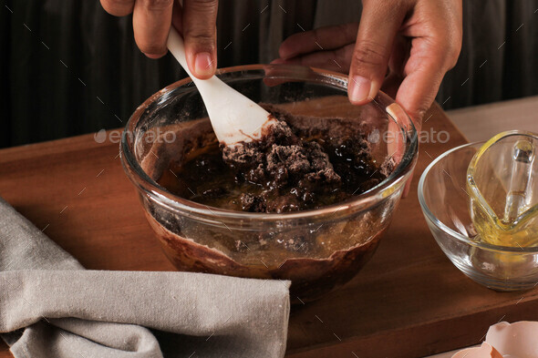 Woman Hand Mixed Chocolate Batter on Clear Bowl with White Spatula
