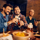 Happy men toasting while drinking beer with friends in bar. - PhotoDune Item for Sale