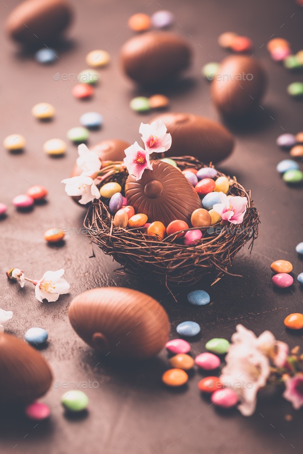 Sweet Easter - Chocolate eggs and colorful chocolate beans in bird nest - Stock Photo - Images