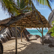 Straw canopy on sandy beach with amazing rock formations, turquoise ocean and some palm trees - PhotoDune Item for Sale