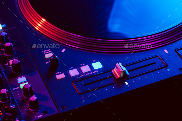 Close up of DJ mixing console in party light - Stock Photo - Images