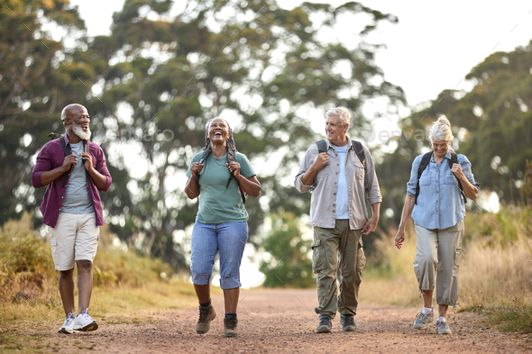 Group Of Active Senior Friends Enjoying Hiking Through Countryside Walking Along Track Together - Stock Photo - Images
