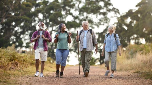 Group Of Active Senior Friends Enjoying Hiking Through Countryside Walking Along Track Together - Stock Photo - Images