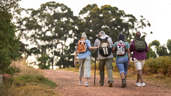 Rear View Of Active Senior Friends Enjoying Hiking Through Countryside Walking Along Track Together - Stock Photo - Images