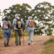 Rear View Of Active Senior Friends Enjoying Hiking Through Countryside Walking Along Track Together - PhotoDune Item for Sale