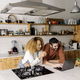 Couple looking at laptop in kitchen. - PhotoDune Item for Sale