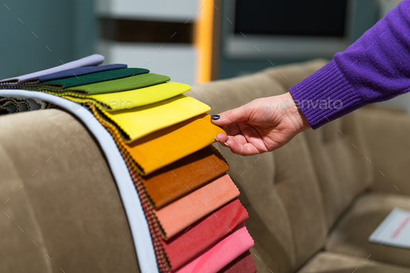 A women looks at tissue samples. Selects the color of the sofa. - Stock Photo - Images