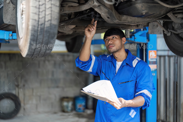 Portrait Shot of a Handsome Mechanic Working on a Vehicle in a Car Service. Professional Repairman - Stock Photo - Images