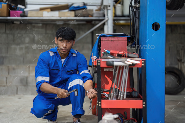 Portrait Shot of a Handsome Mechanic Working on a Vehicle in a Car Service. Professional Repairman - Stock Photo - Images