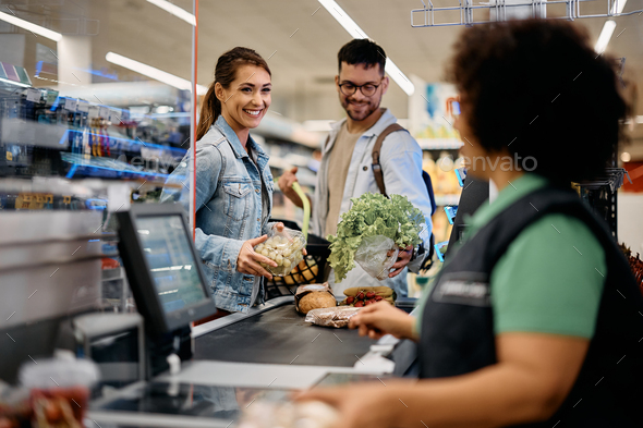 Young happy couple buying groceries in the supermarket. - Stock Photo - Images