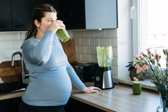 Green Smoothies Recipes For Pregnancy and Postpartum, Prenatal Nutrition. Pregnant woman preparing - Stock Photo - Images