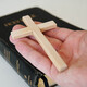 Christian catholic man holding a cross. Old Holy Bible on the table. - PhotoDune Item for Sale