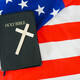 Old Holy Bible with a cross on american flag. Copy space. - PhotoDune Item for Sale