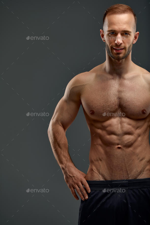 Handsome young sporty man athlete with muscular body and abdominal