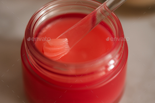 Using lip balm mask with plastic spoon closeup - Stock Photo - Images