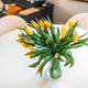 Flower bouquet from yellow tulips in vase on white table background In a living room. Closeup. - PhotoDune Item for Sale