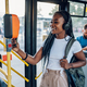 African american woman riding in a bus and using a smartphone for paying a ticket - PhotoDune Item for Sale