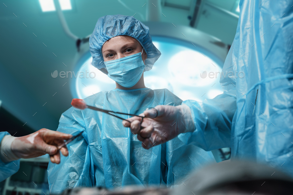 Female surgeon looking at camera in operating room