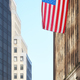 American flag with buildings in background, selective focus, New York City, USA. - PhotoDune Item for Sale