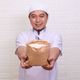 Asian Muslim man hand giving alms bag of rice. Zakah fitrah concept. - PhotoDune Item for Sale