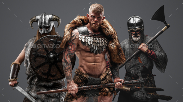 Three viking from past with axes against gray background - Stock Photo - Images