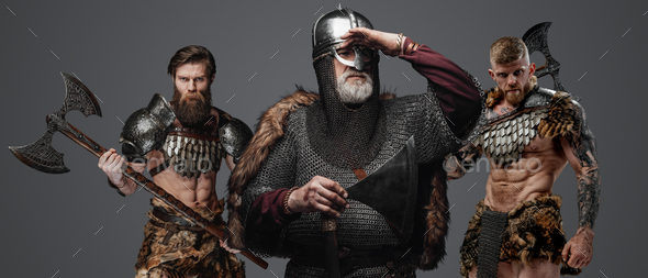 Three viking from past with axes against gray background - Stock Photo - Images