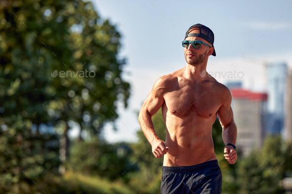 Sporty man jogging in a park stock photo