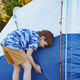 cute little caucasian boy helping to put up a tent. Family camping concept - PhotoDune Item for Sale