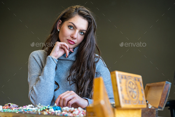reflection of a woman in mirror choosing and trying different jewelry, soft focus, closeup - Stock Photo - Images