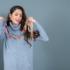 elegant woman in a long gray sweater has fun with many bead chains and jewelry, isolated on gray - PhotoDune Item for Sale