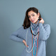elegant woman in a long gray sweater has fun with many bead chains and jewelry, isolated on gray - PhotoDune Item for Sale