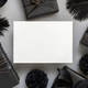 Blank card between Wrapped Gift Boxes, black paper flowers and feathers, mockup - PhotoDune Item for Sale