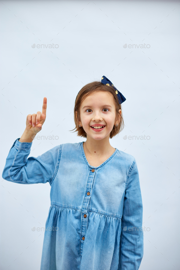 Teen girl child wearing jeans dress make finger up - Stock Photo - Images