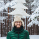 Vertical portrait of cheerful bearded man has fun alone in winter forest, keeps artificial fir tree - PhotoDune Item for Sale
