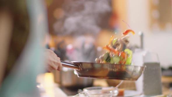 Chef Tossing Vegetables on Pan while Frying alt