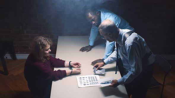 Two Police Officers and Woman Criminal in Interrogation Room alt