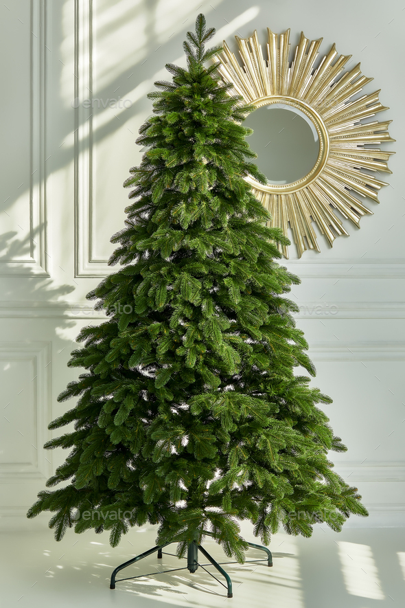 Artificial Christmas green tree without decorations on a metal stand