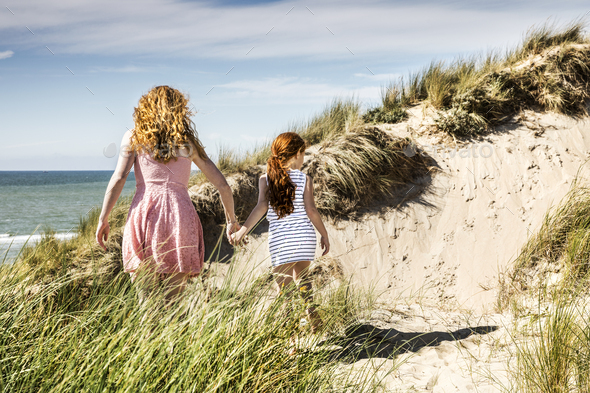 Netherlands, Zandvoort, mother and daughter walking in beach dunes ...