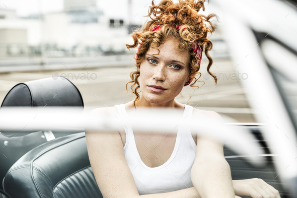 Portrait of redheaded woman in sports car