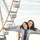 Young women best friends enjoying time together outdoors at ferris wheel - PhotoDune Item for Sale