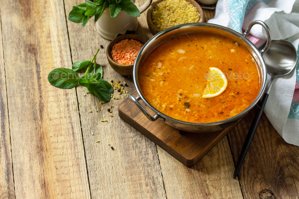 Turkish cuisine. Traditional soup with rice, lentils and mint on a rustic table. Copy space. - Stock Photo - Images