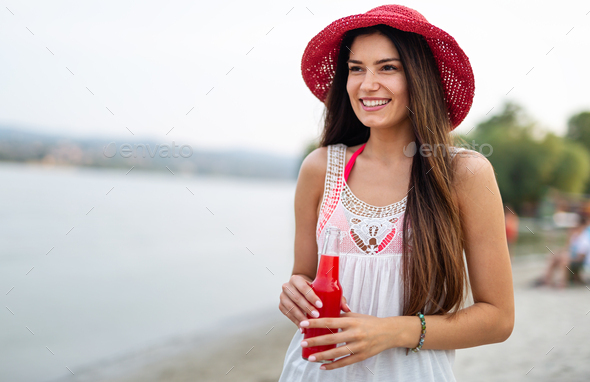 Portrait of happy woman drinking cocktail in summer and enjoying her vacation - Stock Photo - Images
