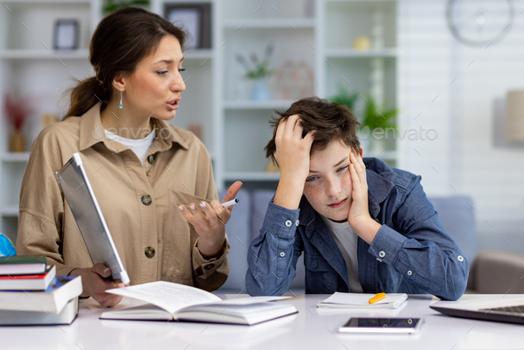 Studying at home, home teacher woman explaining school material to boy student, home school sitting