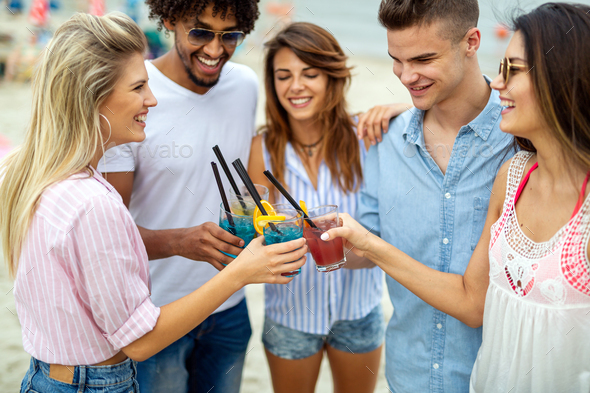 Friends at the beach drinking cocktails having fun on summer vacation - Stock Photo - Images