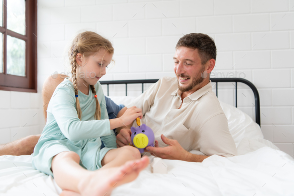 Father teaches daughter how to save money so that the child will have the skills to manage money - Stock Photo - Images