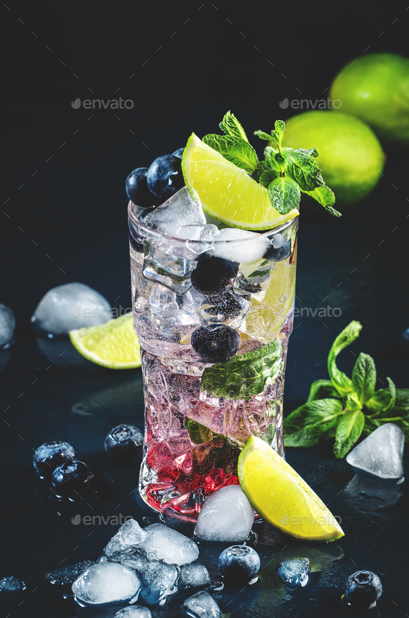 Blueberry Mojito cocktail drink with lime, white rum, soda, cane sugar, mint, and ice - Stock Photo - Images