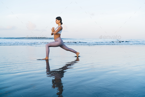 Female Fitness Trainer on the sand beach sunset background