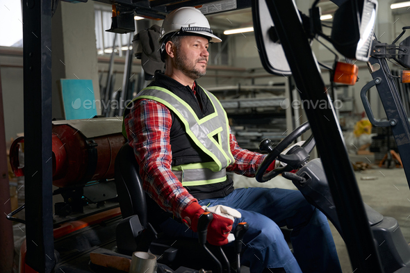 Male sitting in loading truck and working at enterprise - Stock Photo - Images